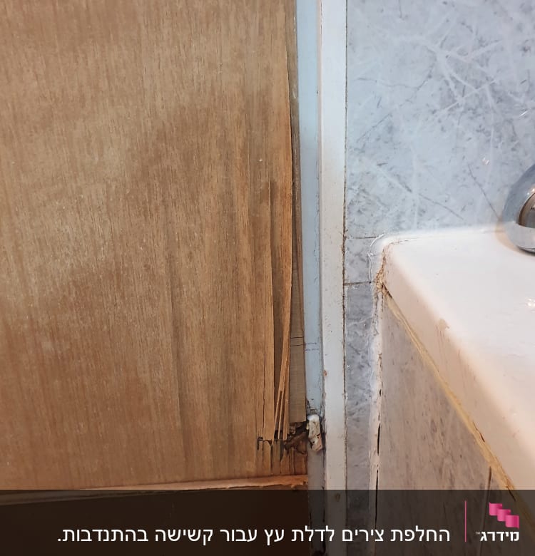 דלת עץ פגומה ליד אמבטיה עם קיר אריחים